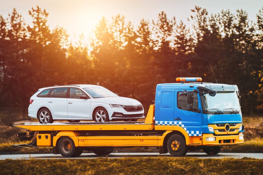 a single car getting transported on a trailer